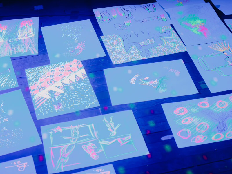 Artwork on the floor at a neon naked life drawing class